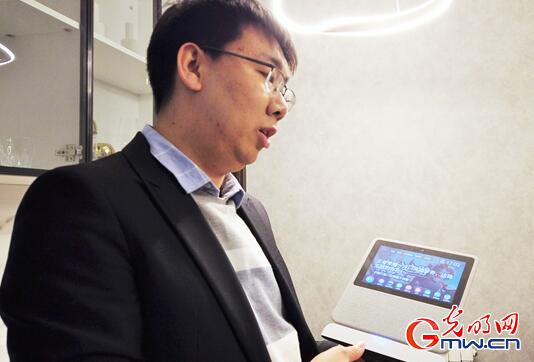 小区工作人员向记者介绍智能音响。光明网记者 徐皓 摄